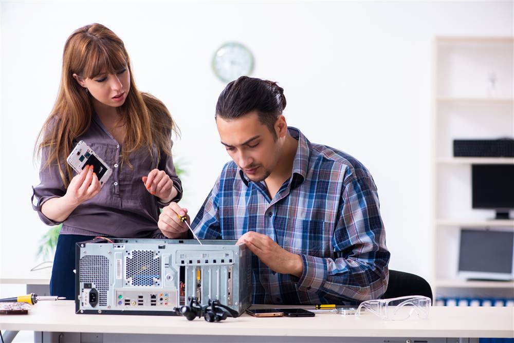 Technicians repairing a desktop computer on site